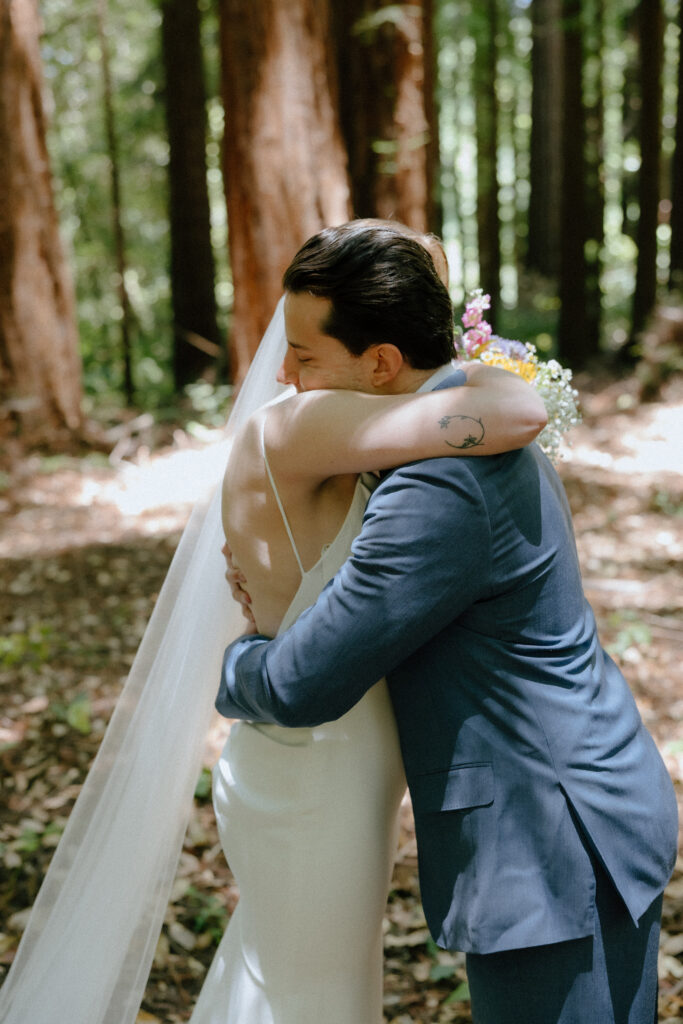 Bride and groom hugging at their elopement in the forest.